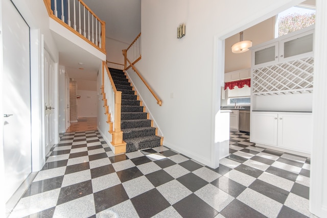 stairway featuring sink and a high ceiling