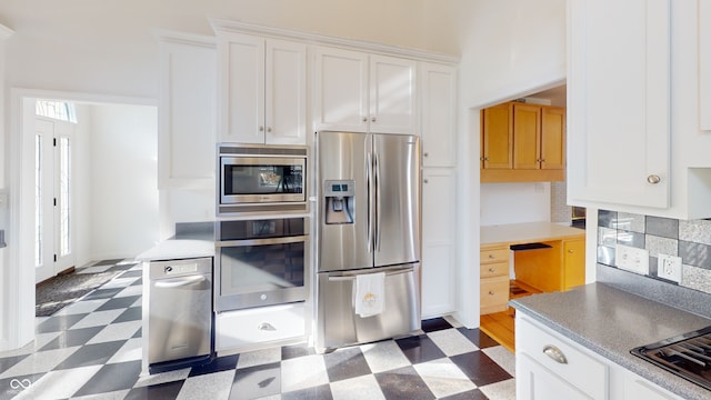 kitchen with decorative backsplash, dark wood-type flooring, white cabinets, and stainless steel appliances