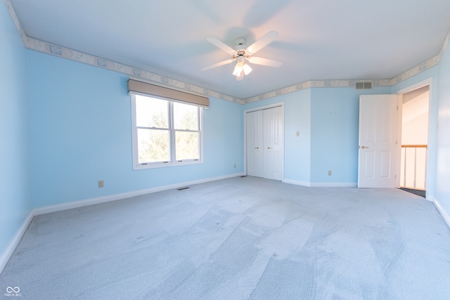 carpeted spare room featuring ceiling fan