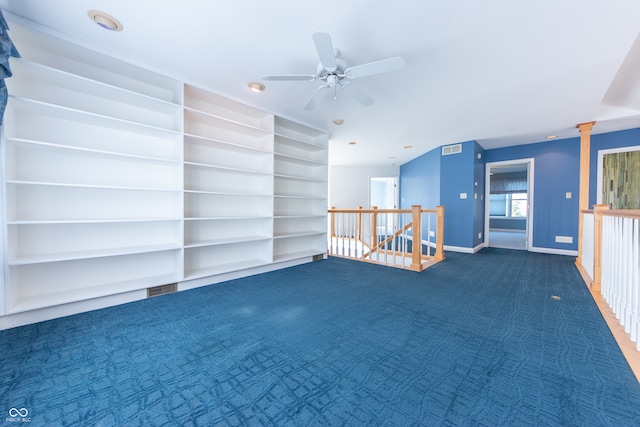 spare room with dark colored carpet, ceiling fan, and built in features