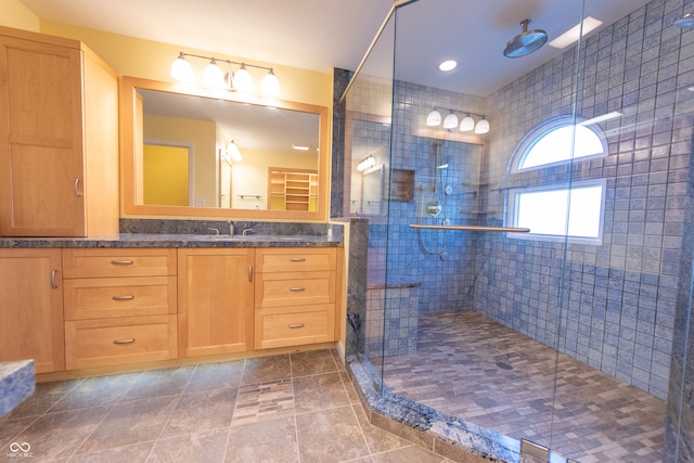 bathroom with tile patterned flooring, vanity, an enclosed shower, and tile walls