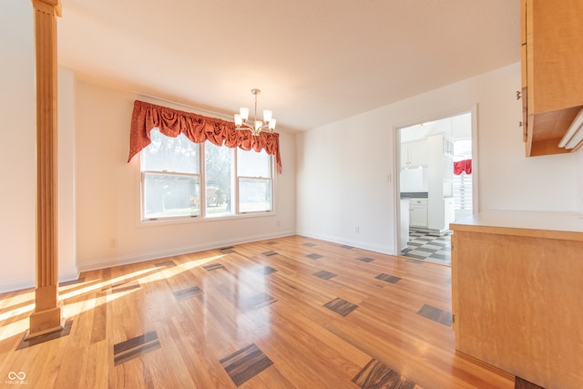 unfurnished dining area with light hardwood / wood-style flooring and a chandelier