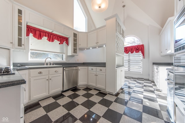 kitchen with white cabinetry, sink, hanging light fixtures, high vaulted ceiling, and appliances with stainless steel finishes