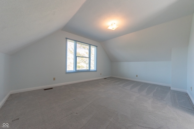 bonus room with carpet flooring, a textured ceiling, and vaulted ceiling