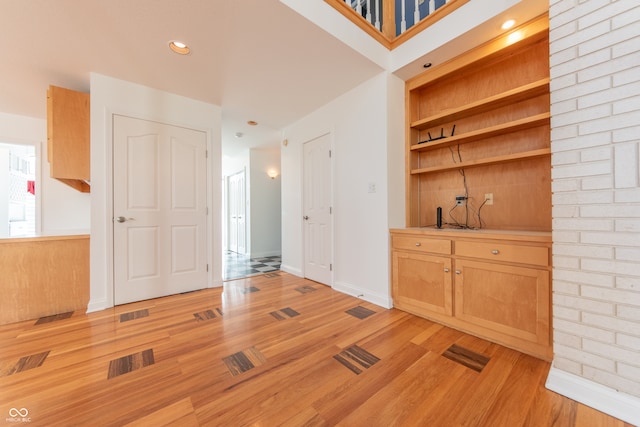 bar with light brown cabinetry and light wood-type flooring