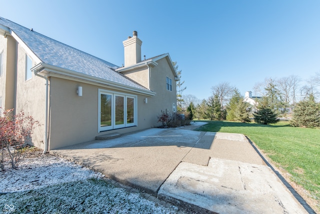 rear view of property with a lawn and a patio area