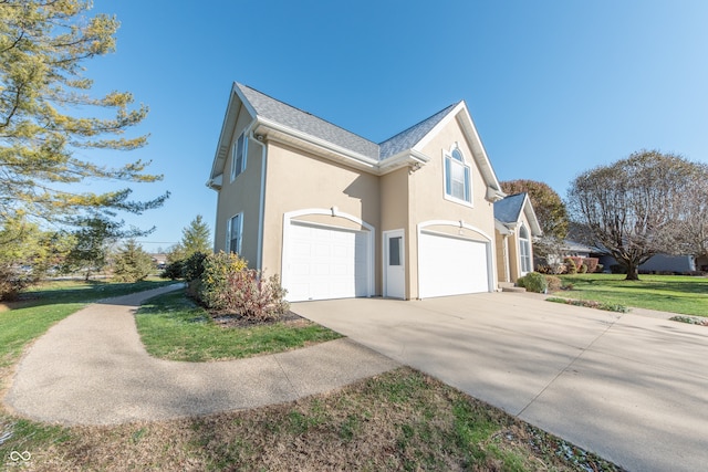 view of property exterior featuring a yard and a garage