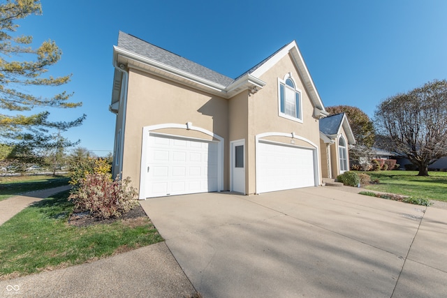 view of side of property featuring a yard and a garage