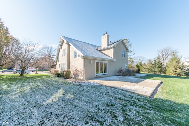 rear view of house with a lawn, a patio area, and french doors