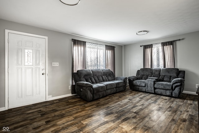 living room featuring dark wood-type flooring and a healthy amount of sunlight