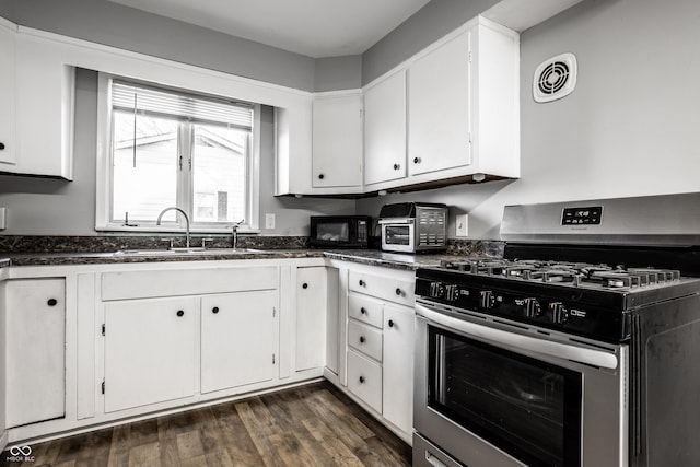 kitchen with dark hardwood / wood-style floors, white cabinetry, sink, and stainless steel range with gas stovetop