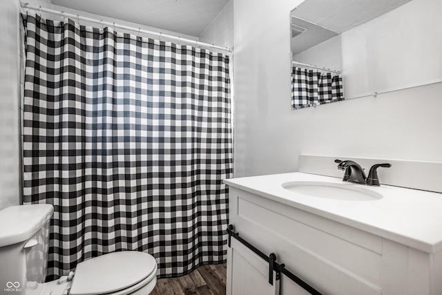 bathroom with vanity, hardwood / wood-style flooring, and toilet