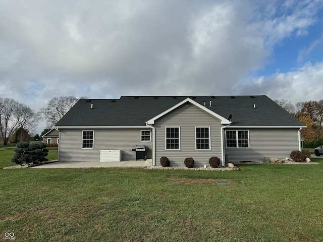 rear view of property with a lawn and a patio