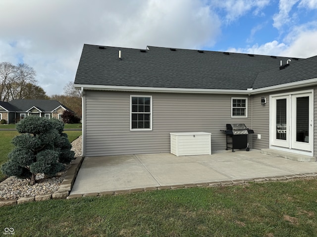 back of property with a patio area, a lawn, and french doors