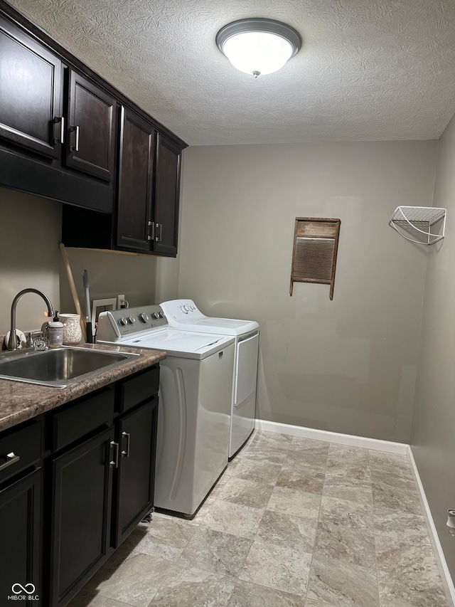 washroom with sink, separate washer and dryer, a textured ceiling, and cabinets