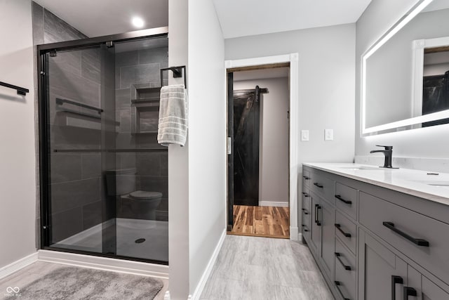 bathroom with vanity, wood-type flooring, and an enclosed shower