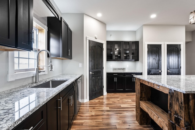 9462 N Rushville Rd, Knightstown, IN 46148 - kitchen with a sink, light wood finished floors, dishwasher, light stone counters, and dark cabinets