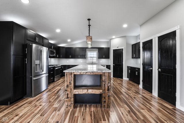 9462 N Rushville Rd, Knightstown, IN 46148 - kitchen featuring appliances with stainless steel finishes, dark cabinets, wood finished floors, light stone counters, and vaulted ceiling