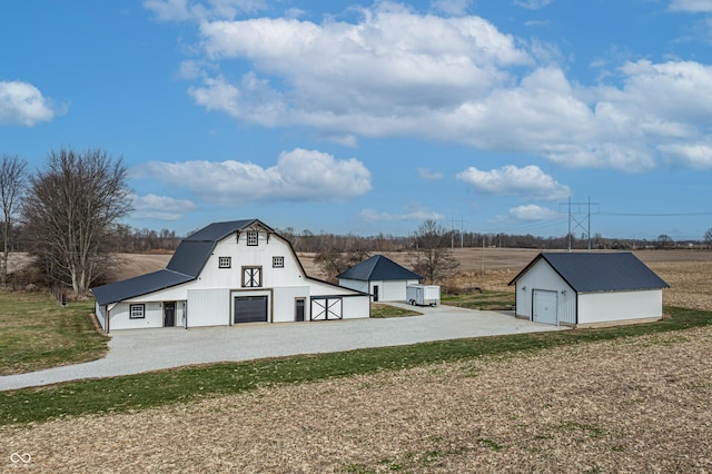 9462 N Rushville Rd, Knightstown, IN 46148 - view of side of home featuring a barn, an outbuilding, a gambrel roof, a garage, and driveway