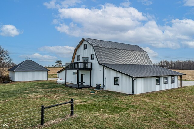 back of house with a lawn, central AC, a balcony, and an outdoor structure