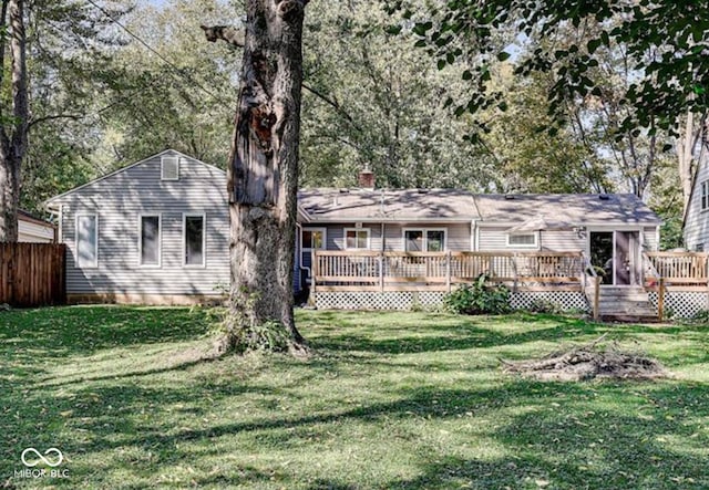 rear view of property with a yard and a deck