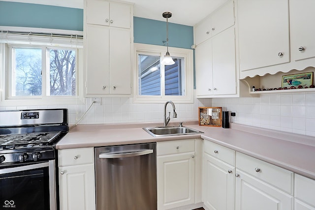 kitchen featuring backsplash, white cabinetry, sink, and appliances with stainless steel finishes