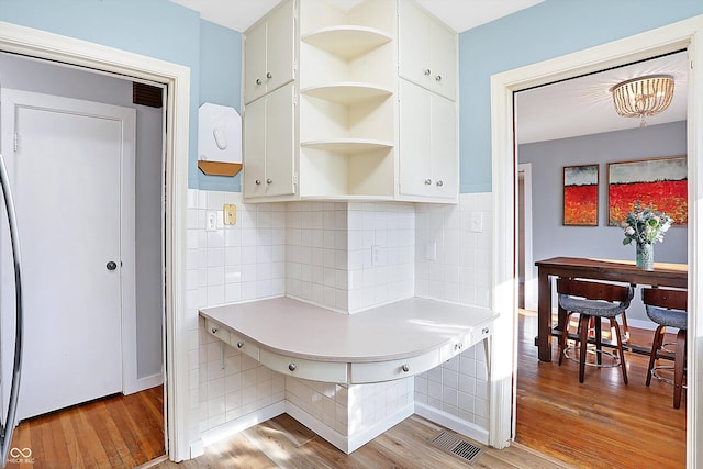 kitchen featuring tasteful backsplash, white cabinetry, and light hardwood / wood-style floors