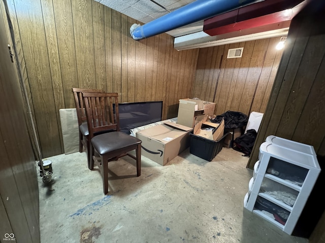 living area featuring wood walls and concrete flooring