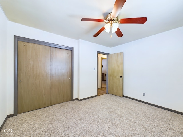 unfurnished bedroom with ceiling fan, a closet, and light carpet