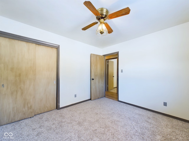 unfurnished bedroom with light colored carpet, ceiling fan, and a closet