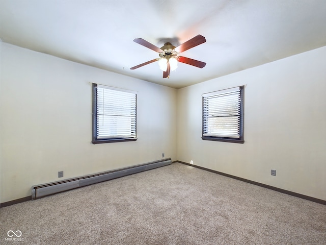 carpeted empty room with a healthy amount of sunlight, baseboard heating, and ceiling fan