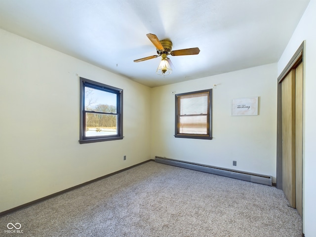 unfurnished bedroom featuring ceiling fan, a closet, light carpet, and a baseboard heating unit