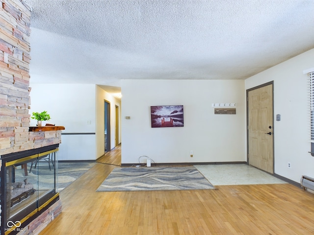 interior space with a textured ceiling and hardwood / wood-style floors