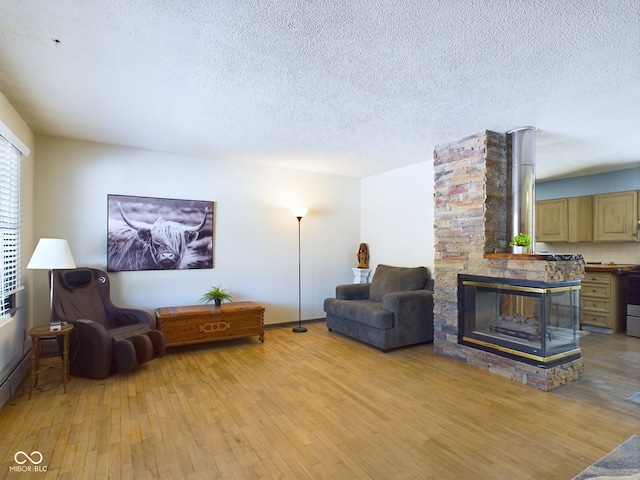 sitting room featuring light hardwood / wood-style floors, a textured ceiling, and a fireplace