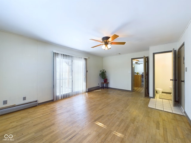 unfurnished room with a baseboard radiator and light hardwood / wood-style floors