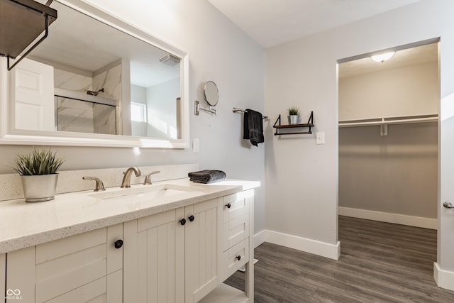 bathroom featuring walk in shower, wood-type flooring, and vanity