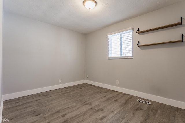 unfurnished room with dark hardwood / wood-style floors