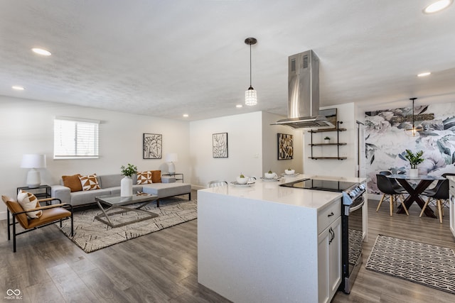 kitchen featuring white cabinetry, hanging light fixtures, dark hardwood / wood-style floors, stainless steel range with electric stovetop, and island range hood