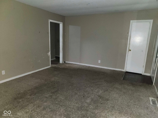 spare room featuring dark carpet