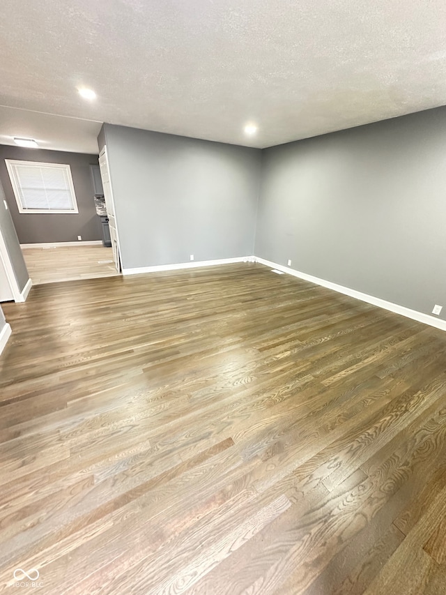 empty room featuring wood-type flooring and a textured ceiling