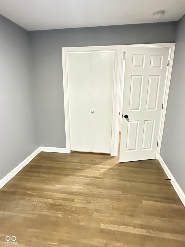 unfurnished bedroom with a closet and wood-type flooring