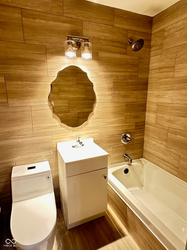 full bathroom featuring vanity, toilet, wood-type flooring, and tiled shower / bath