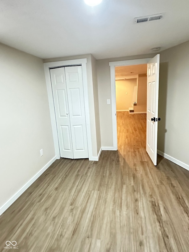 unfurnished bedroom featuring a closet and hardwood / wood-style flooring