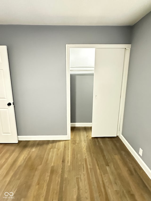 unfurnished bedroom with a closet and wood-type flooring