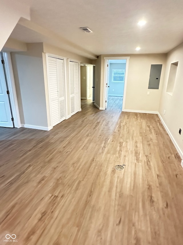 interior space featuring electric panel and light hardwood / wood-style floors