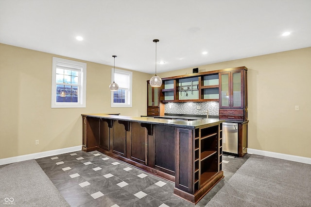 bar featuring dark brown cabinetry, decorative backsplash, pendant lighting, and dark carpet