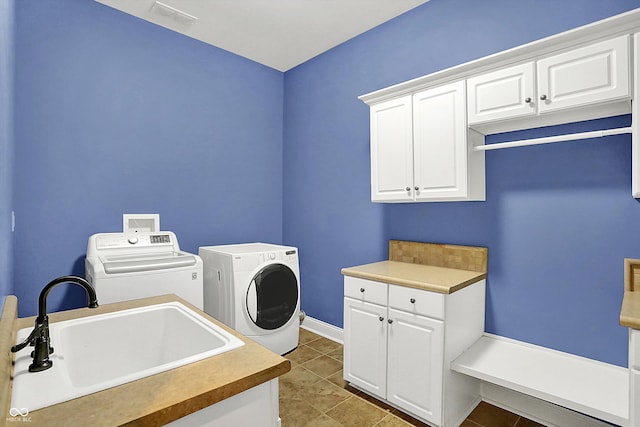 laundry area featuring tile patterned flooring, cabinets, independent washer and dryer, and sink