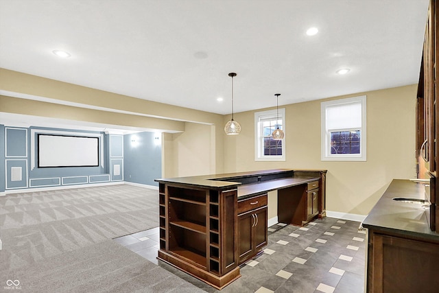 kitchen featuring dark brown cabinets, dark carpet, and hanging light fixtures