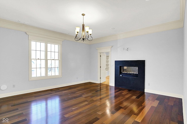 unfurnished living room with crown molding, a multi sided fireplace, dark wood-type flooring, and an inviting chandelier