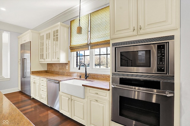 kitchen featuring sink, hanging light fixtures, light stone countertops, appliances with stainless steel finishes, and dark hardwood / wood-style flooring